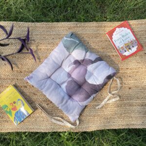 Upcycled chair pad made from repurposed fabrics placed on a mat with books – eco-friendly handmade cushion for sustainable home décor.