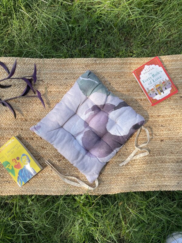 Upcycled chair pad made from repurposed fabrics placed on a mat with books – eco-friendly handmade cushion for sustainable home décor.