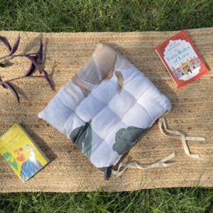 Upcycled chair pad made from repurposed fabrics placed on a mat with books – eco-friendly handmade cushion for sustainable home décor.
