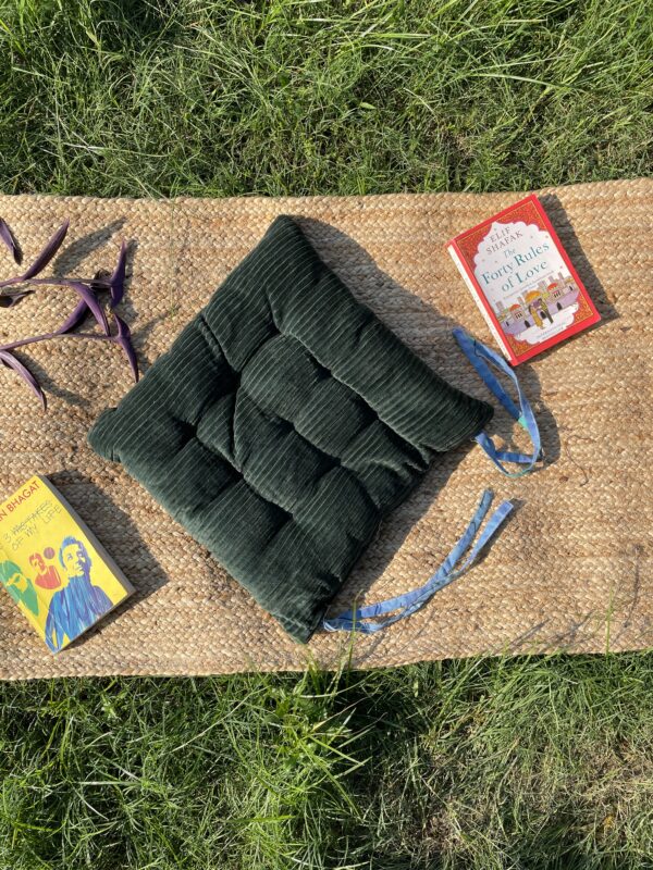 Upcycled chair pad made from repurposed fabrics placed on a mat with books – eco-friendly handmade cushion for sustainable home décor.