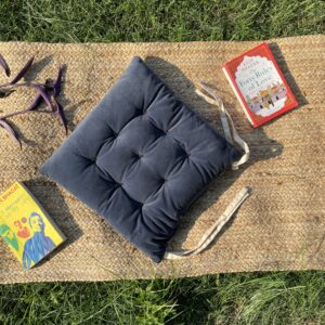 Upcycled chair pad made from repurposed fabrics placed on a mat with books – eco-friendly handmade cushion for sustainable home décor.