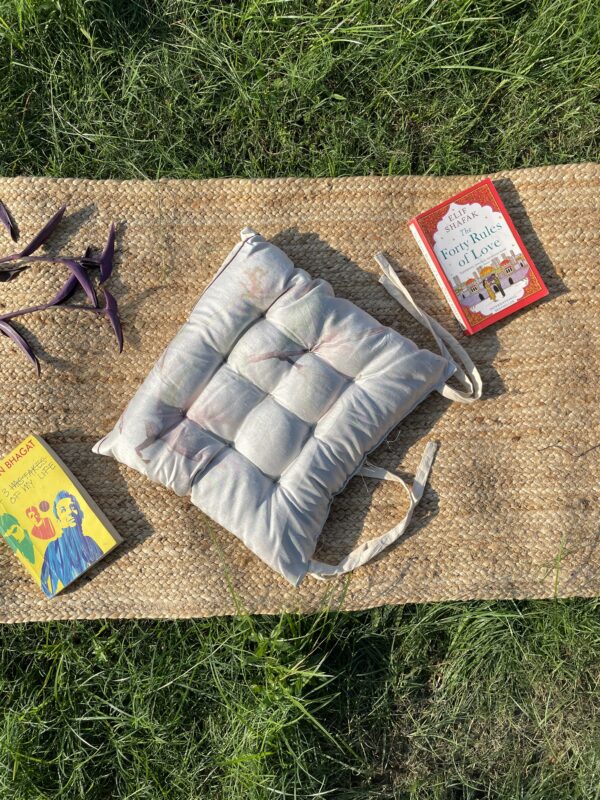 Upcycled chair pad made from repurposed fabrics placed on a mat with books – eco-friendly handmade cushion for sustainable home décor.