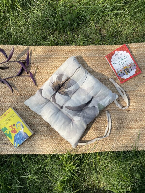 Upcycled chair pad made from repurposed fabrics placed on a mat with books – eco-friendly handmade cushion for sustainable home décor.