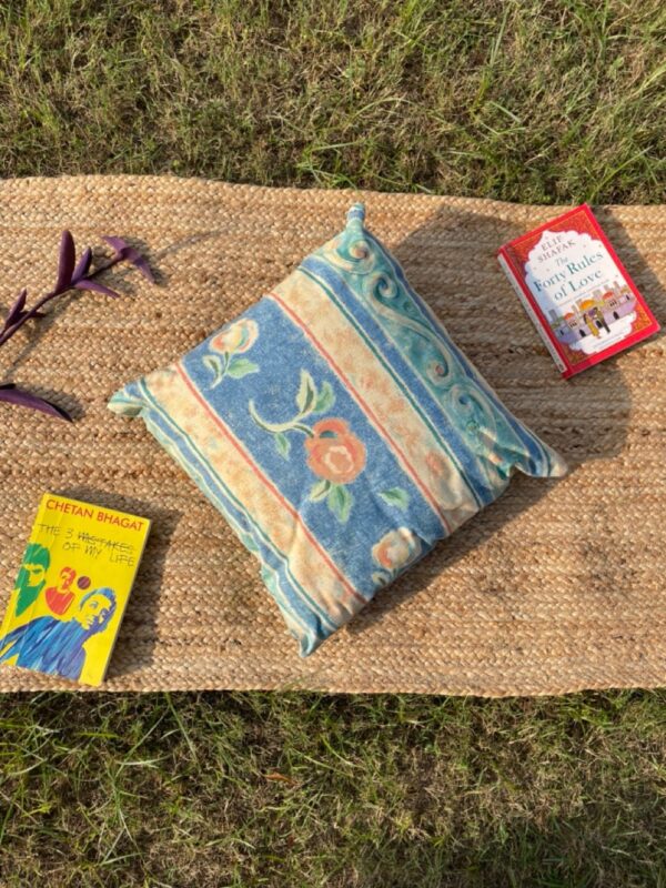 Upcycled cushion made from repurposed fabrics, eco-friendly and sustainable home décor accent piece.