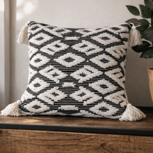 Sustainable designer cushion by Respun in black and ivory geometric weave, 18 x 18 inches with filler, styled on a rustic wooden console.